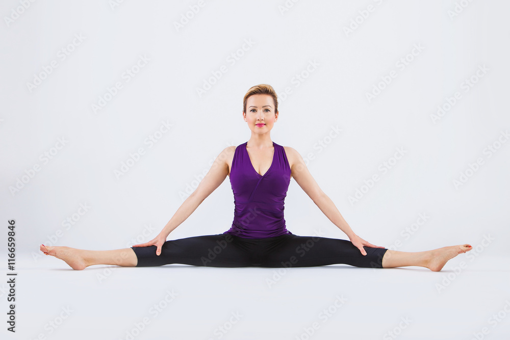 Beautiful young woman doing yoga on a gray studio background Beautiful young woman doing yoga on a gray studio background
