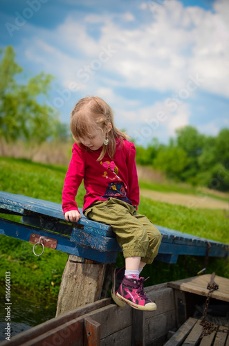 Cute girl sits on the fishing bridge © kobolia