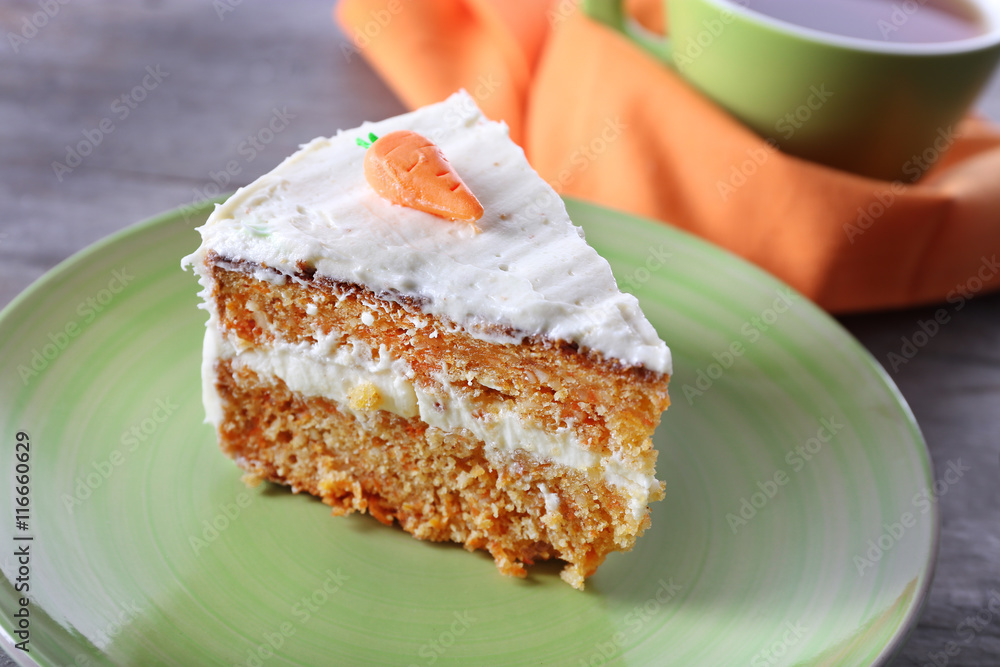 Piece of carrot cake with a cup of tea on wooden table Piece of carrot cake with a cup of tea on wooden table