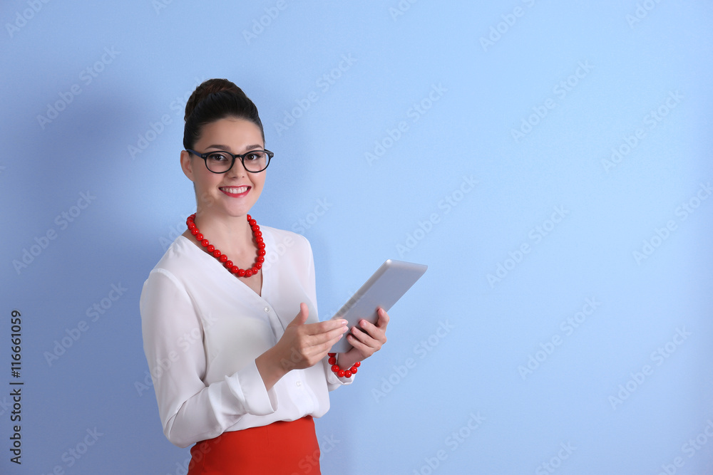 Pretty young woman holding tablet on light background Pretty young woman holding tablet on light background