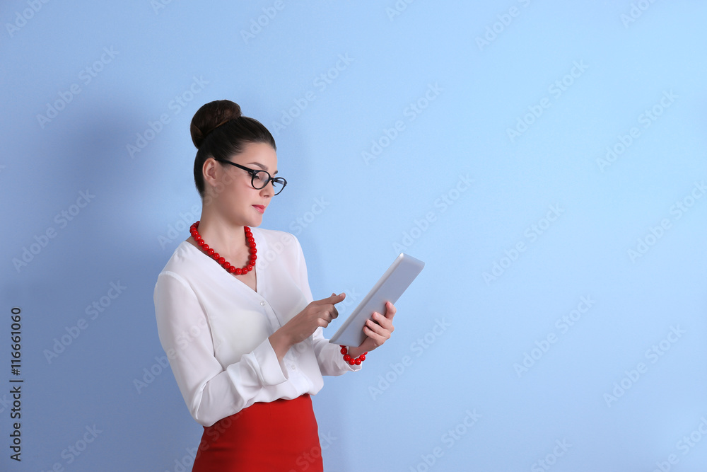 Pretty young woman holding tablet on light background Pretty young woman holding tablet on light background