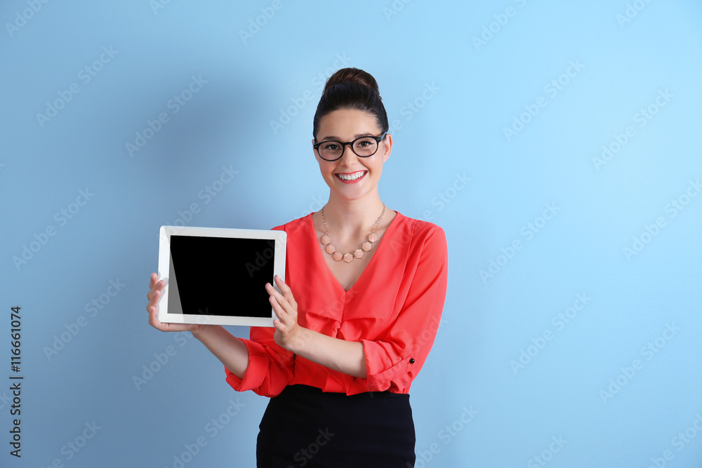 Pretty young woman holding tablet on light background Pretty young woman holding tablet on light background