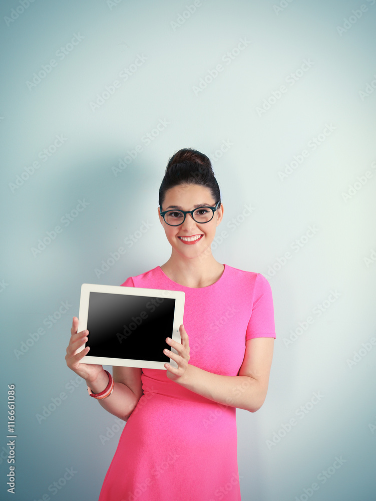 Cute woman holding tablet on light background Cute woman holding tablet on light background