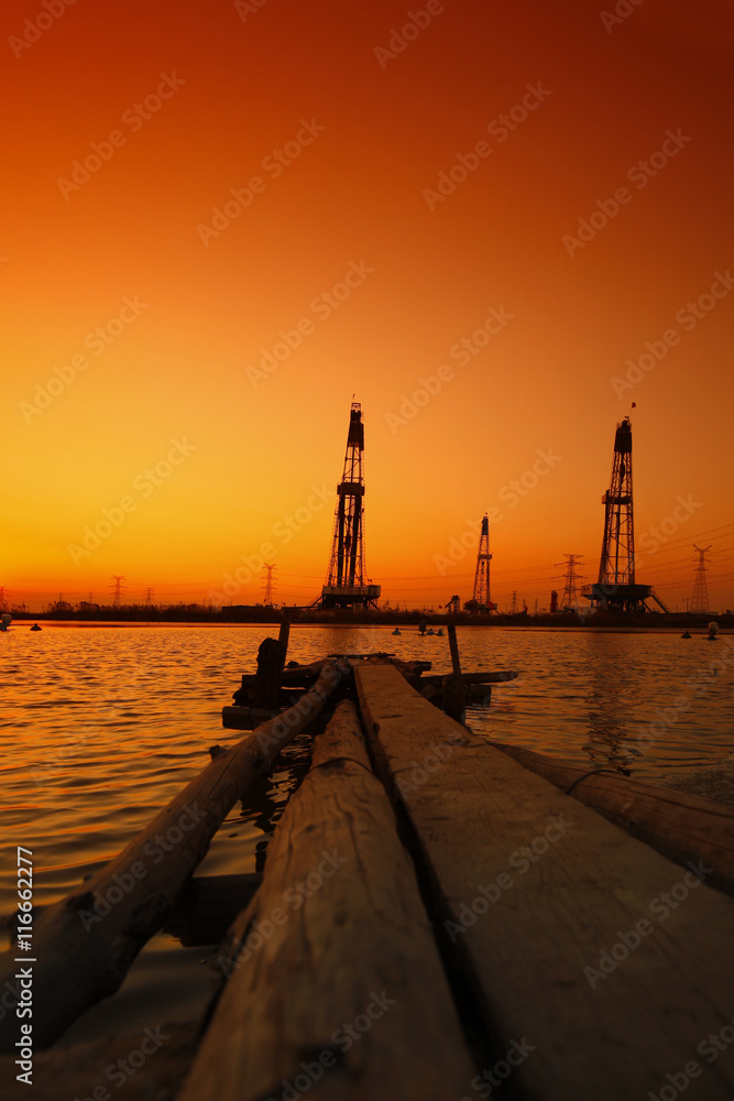 Obraz premium Sunset of oil drilling rig in the sea