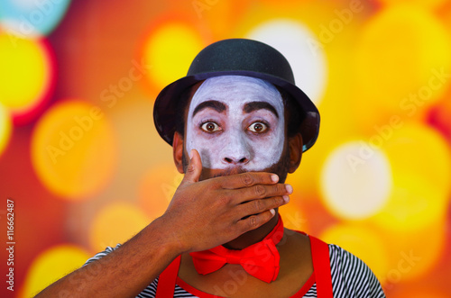 Headshot pantomime man with facial paint posing for camera using hands to cover Fototapet