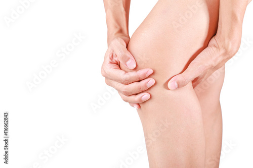 Knee pain.Female holding hand to spot of knee pain on white background.