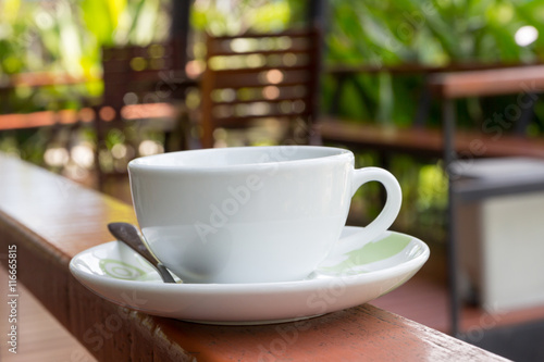 White coffee cup on the banister.