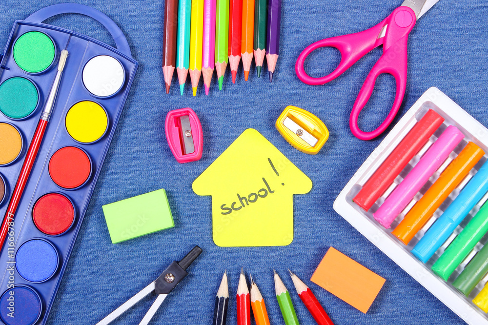 School supplies and shape of building on jeans background, back to school concept School supplies and shape of building on jeans background, back to school concept