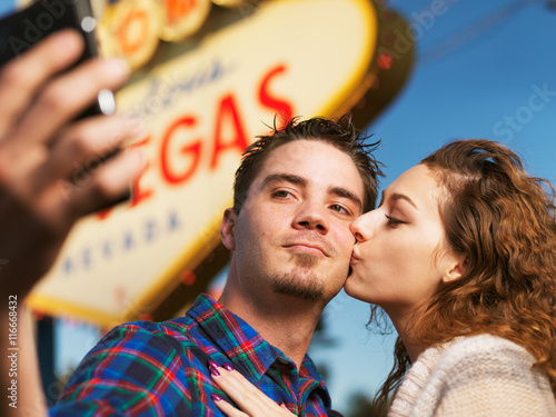 Photography happy couple take selfie in front of the welcome to las vegas sign