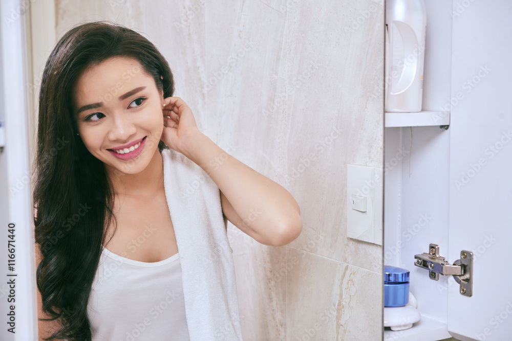 Smiling Asian woman getting ready in her bathroom Smiling Asian woman getting ready in her bathroom