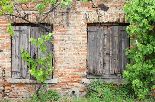 brick wall with wooden windows frames of the old house