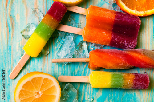 Wallpaper Mural Colorful ice lolly and friuts on blue wooden background Torontodigital.ca