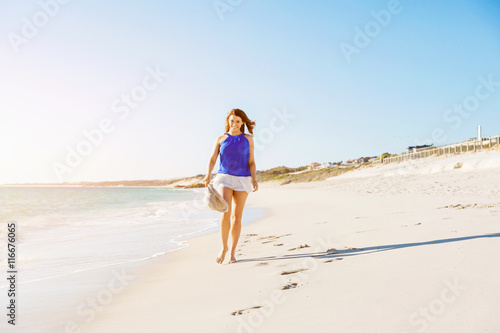 Young woman walking along the beach