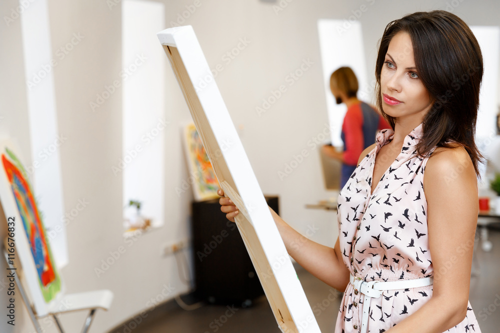 Young caucasian woman standing in art gallery front of paintings Young caucasian woman standing in art gallery front of paintings