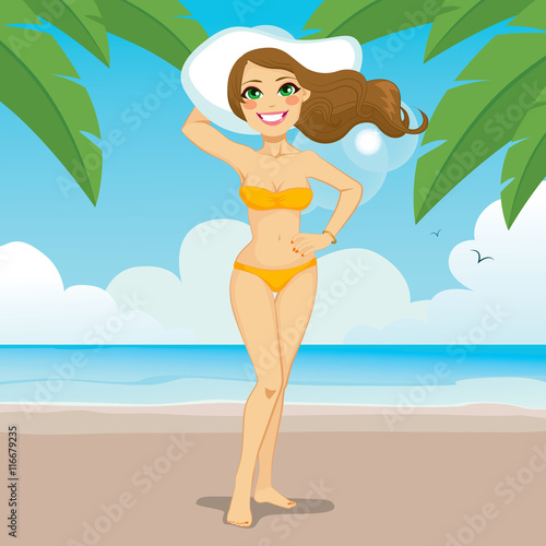 Beautiful light brown haired woman wearing bikini and big white hat standing on tropical beach