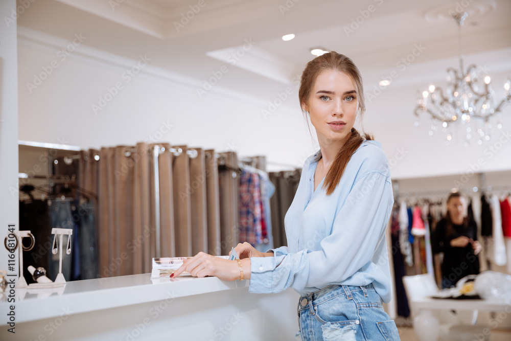 Beautiful young woman standing in clothing store