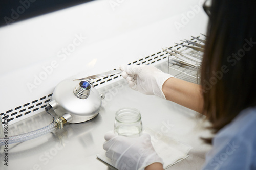 Εκτύπωση καμβά A scientist in lab is burning a knife for hygiene .