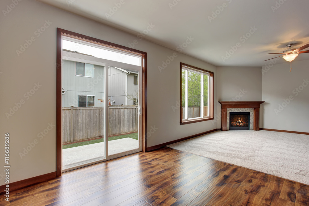 Large empty living room interior with carpet floor and fireplace. Large empty living room interior with carpet floor and fireplace.