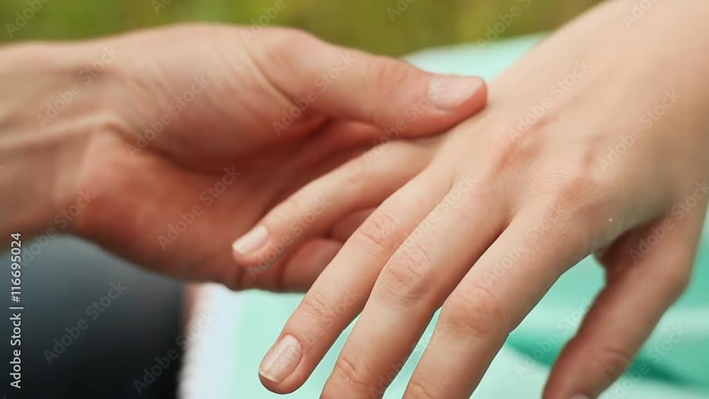 A man puts a ring on the finger of a woman A man puts a ring on the finger of a woman
