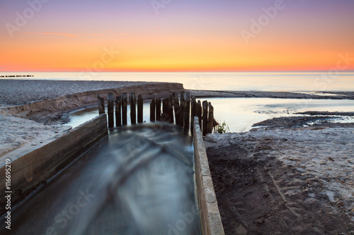 Concrete regulation mouth of the river to Baltic Sea  view during sunset .