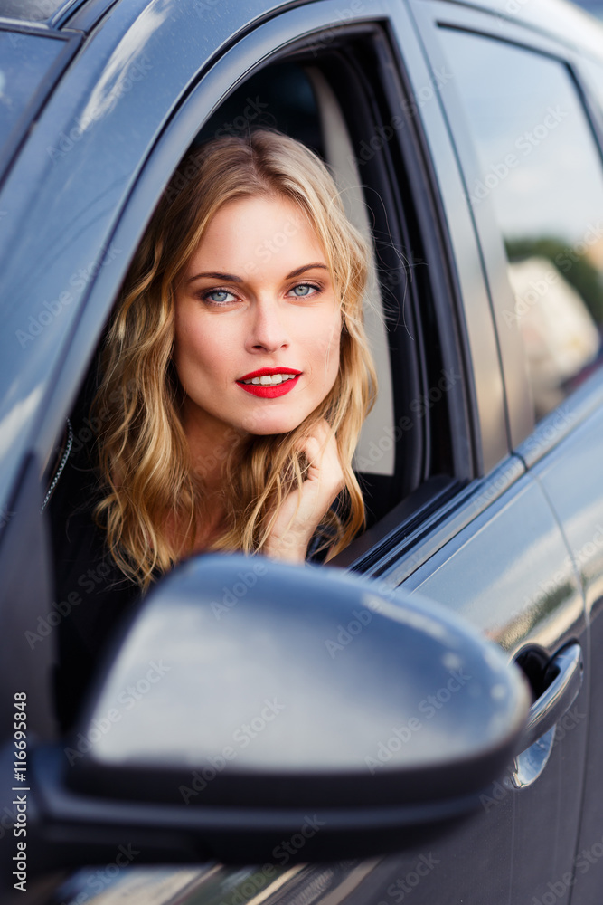 Cute girl with blond hair and natural make-up sitting in the car Cute girl with blond hair and natural make-up sitting in the car