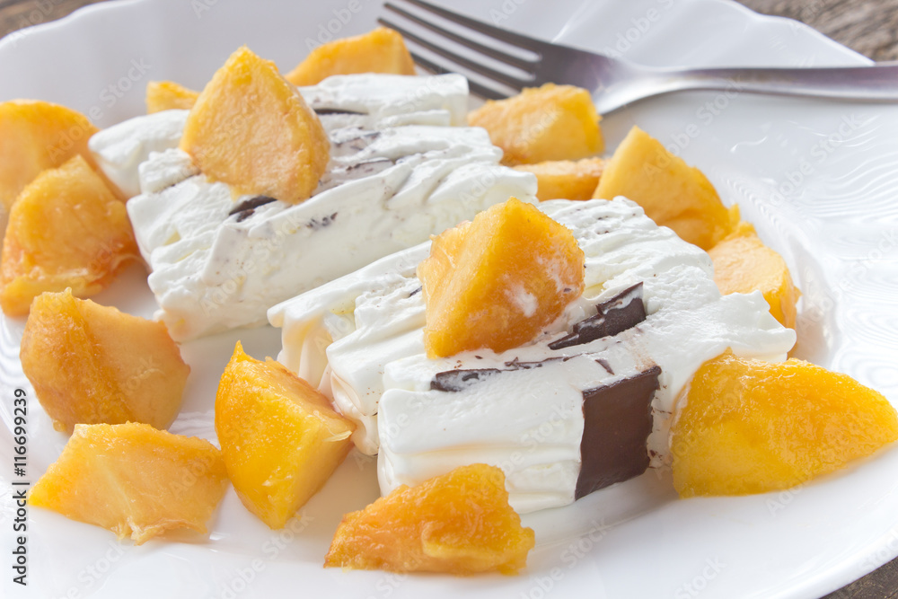 Ice cream cake with peach slices in plate Ice cream cake with peach slices in plate