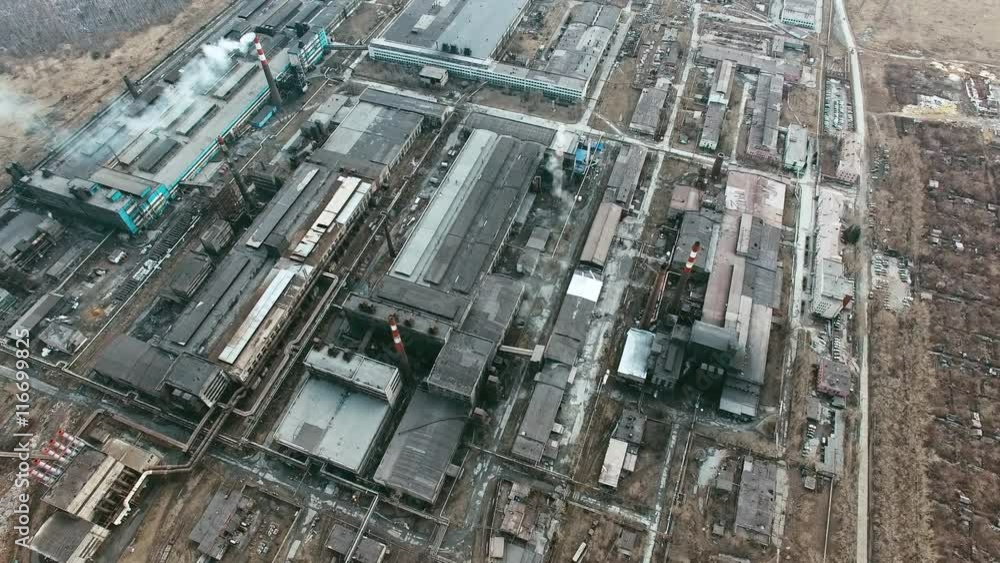Aerial view of large industrial plant consisting of various buildings and constructions with smoking chimneys polluting air Aerial view of large industrial plant consisting of various buildings and constructions with smoking chimneys polluting air