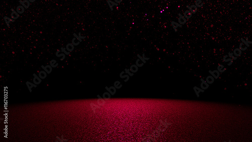 sparkling glitter in shades of pink and purple falling on a flat surface lit by a bright spotlight 