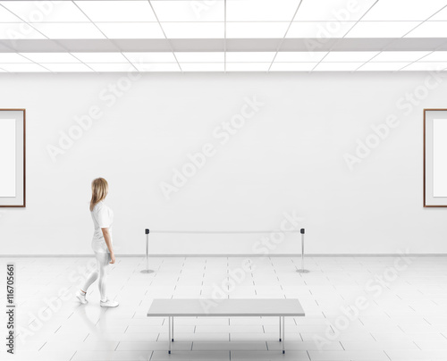 Modern gallery wall mockup. Woman walk in museum hall with blank wal with frames. White clear stand mock up show. Display artwork presentation. Art design empty floor. Expo studio wall in center.