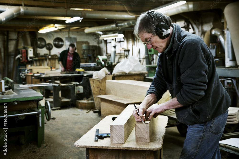 A man working in a furniture maker's workshop. A man working in a furniture maker's workshop.