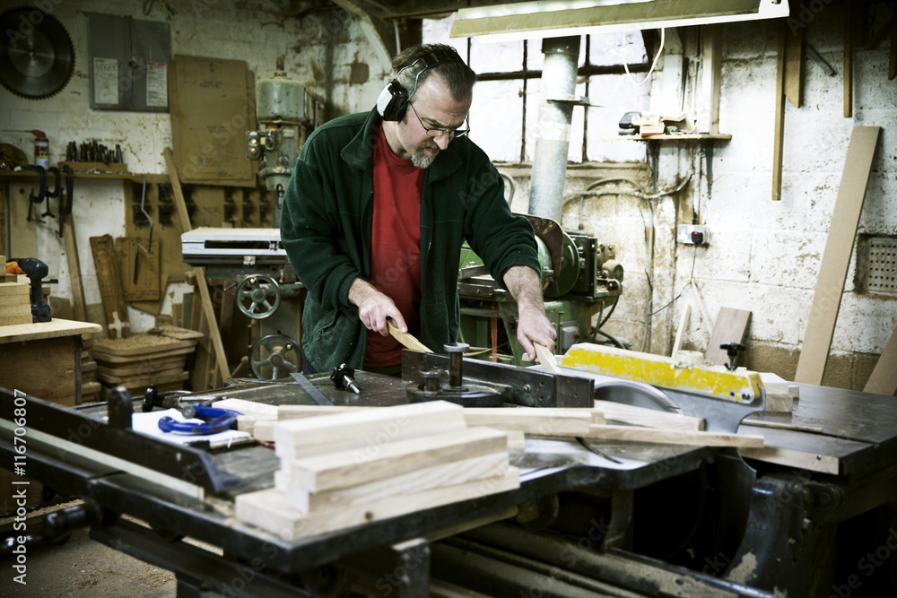 A man working in a furniture maker's workshop. A man working in a furniture maker's workshop.