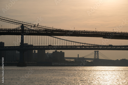 Dark silhouettes of sections of Brooklyn, Manhattan and Willamsburg bridge at dawn