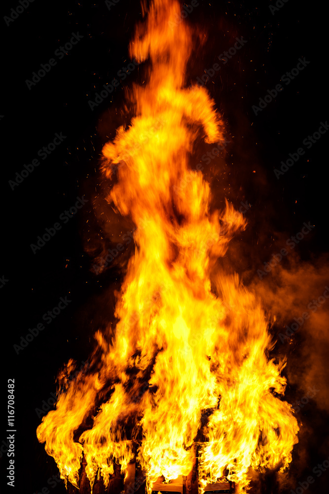 Wooden house roof in fire  on black background