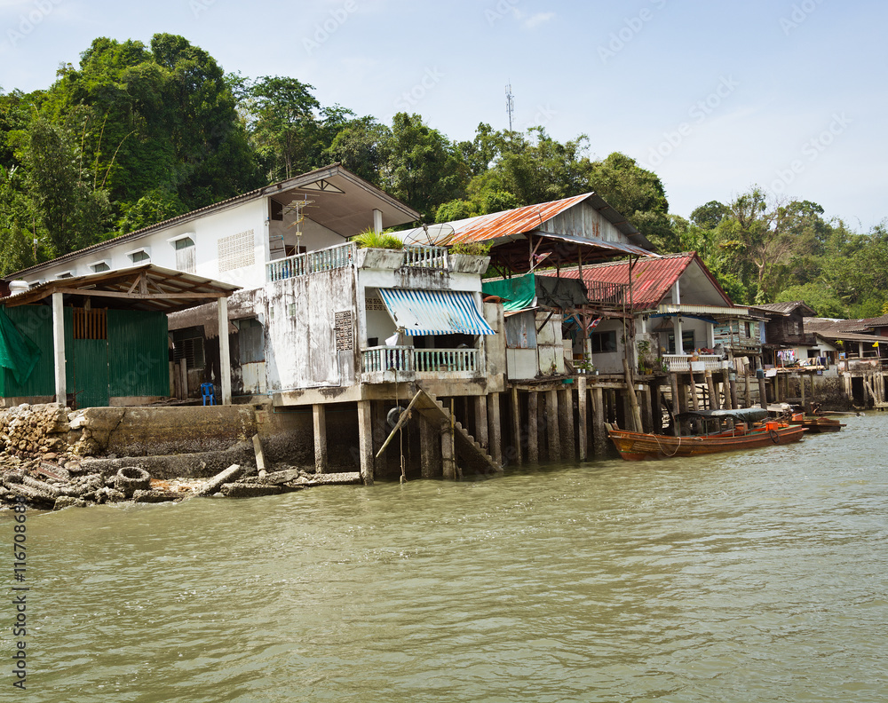 Old houses on river bank. Thailand