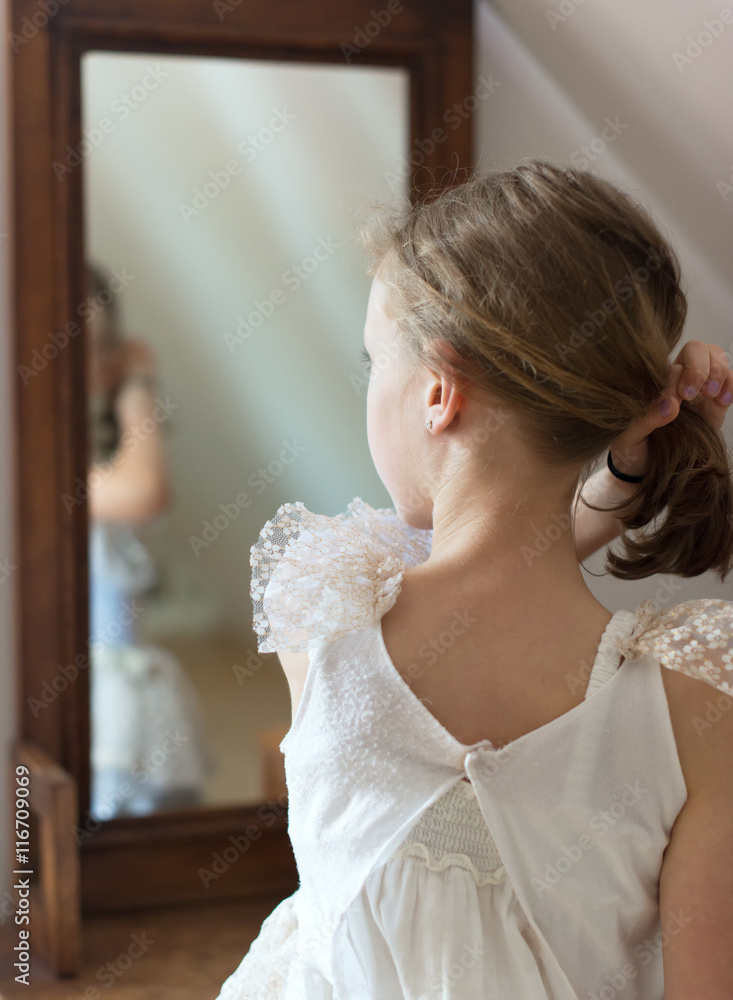 Little girl dresses up in front of the mirror. Little girl dresses up in front of the mirror.