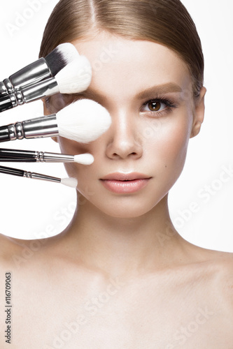Canvas Print Beautiful young girl with a light natural make-up, brushes for cosmetics