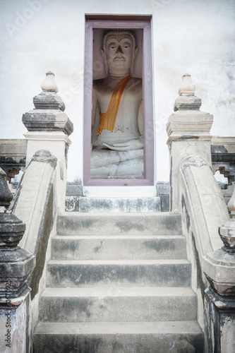 Buddha sits a small room. Thailand, Ayutthaya photo