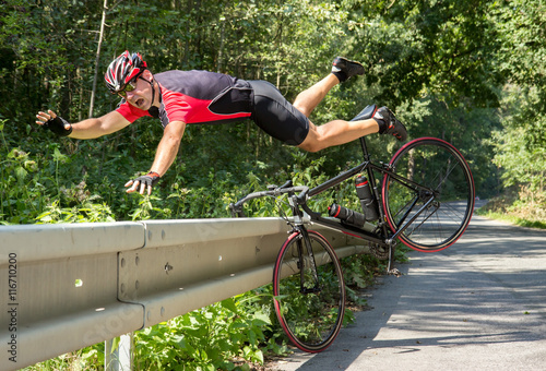 Fototapeta Naklejka Na Ścianę i Meble -  Cyclist falls off the bike into bushes. Accident with bike on road.