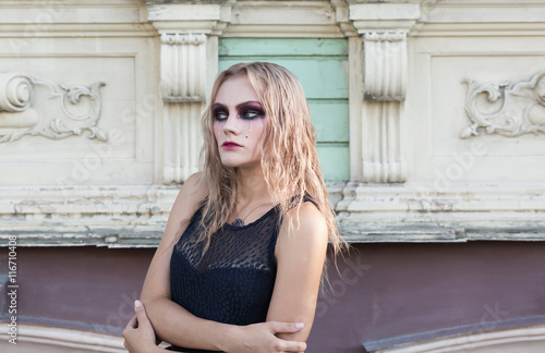 An outdoor fashion gothic style portrait of a beautiful blonde girl