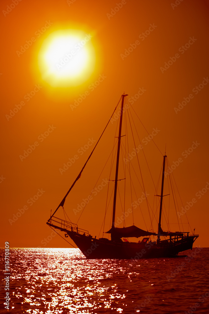 Silhouette of sailing yacht in the tropical sea at sunset. Thail