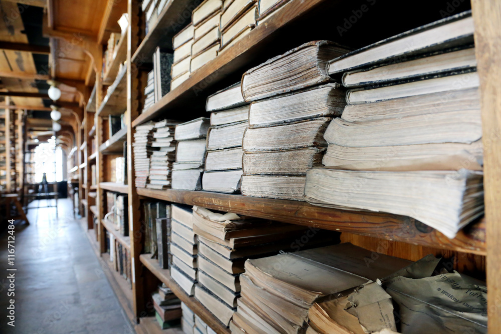 Fototapeta premium Old books on library shelves