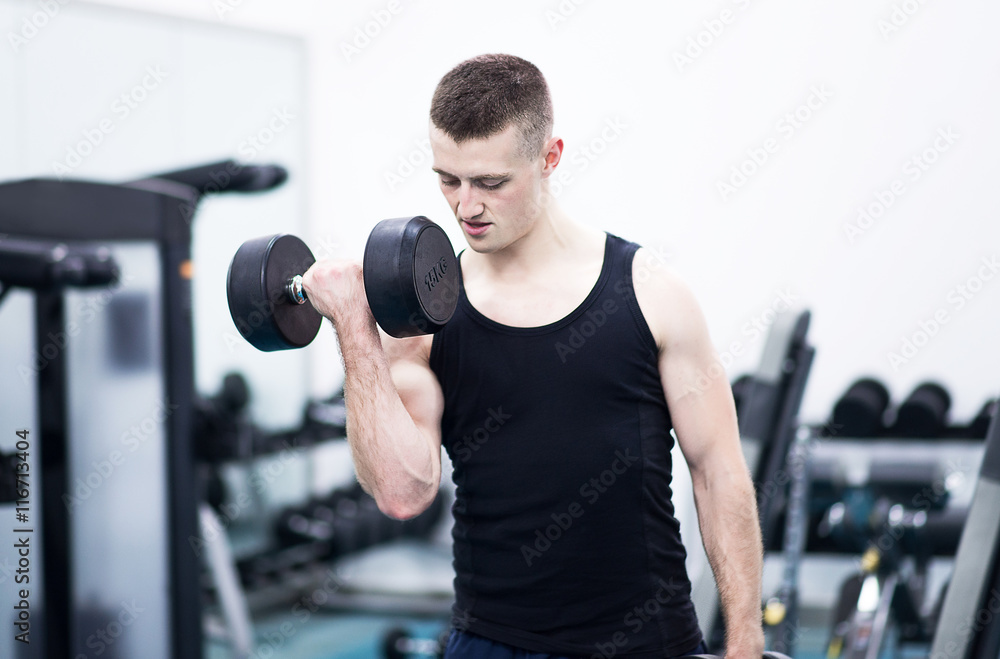 Athletic man with a dumbells in gym Athletic man with a dumbells in gym