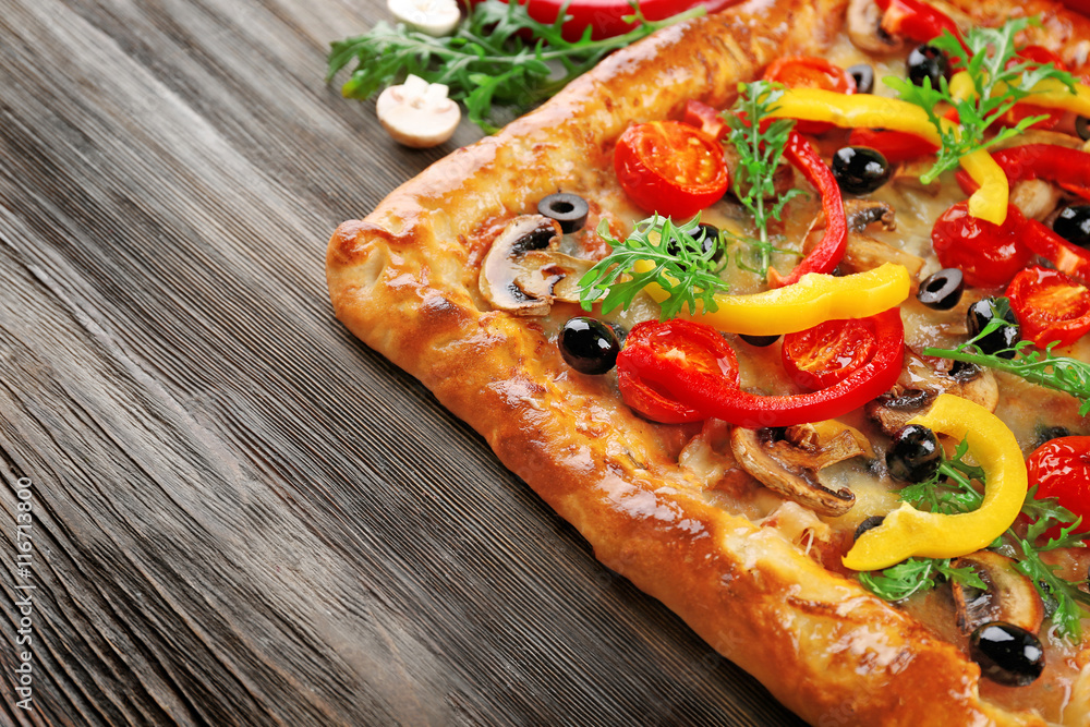 Freshly homemade pizza on wooden table closeup Freshly homemade pizza on wooden table closeup