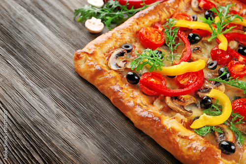 Freshly homemade pizza on wooden table closeup