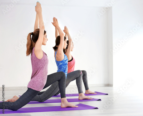 Young women with mats in gym