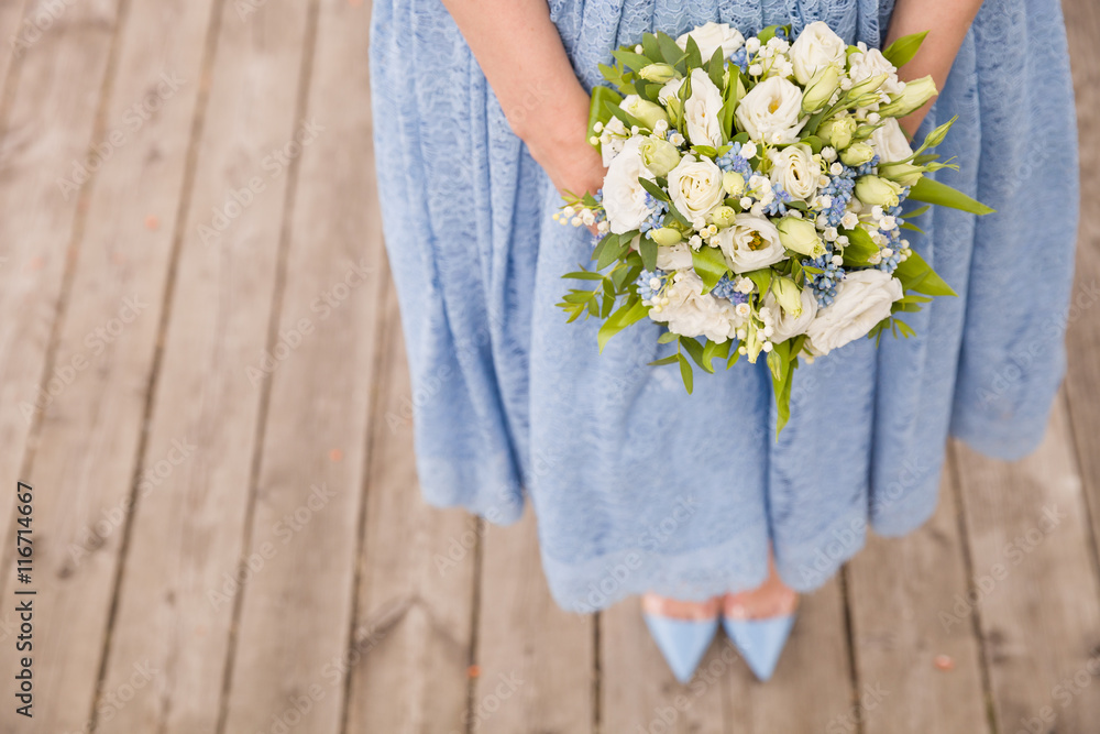 Top view on woman in blue dress holding beautiful wedding bouquet of flowers. Bride.