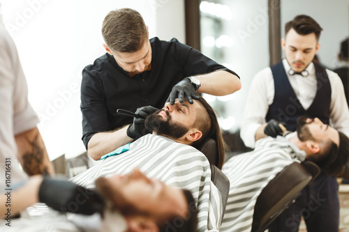 Barbers making a beard form for clients