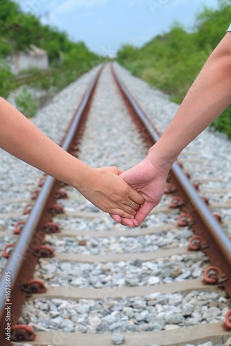 Focusing on holding hand together with blur bokeh train track and tree background photo