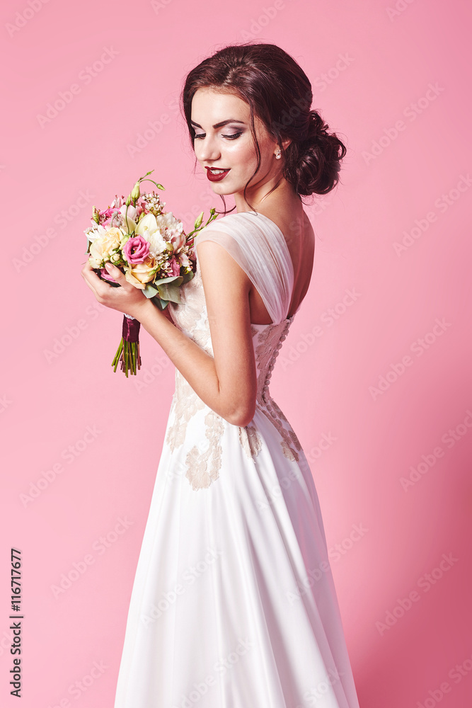 Bride.Young fashion model with perfect skin and make up, beige background, curly hair, flowers in hair Bride.Young fashion model with perfect skin and make up, beige background, curly hair, flowers in hair