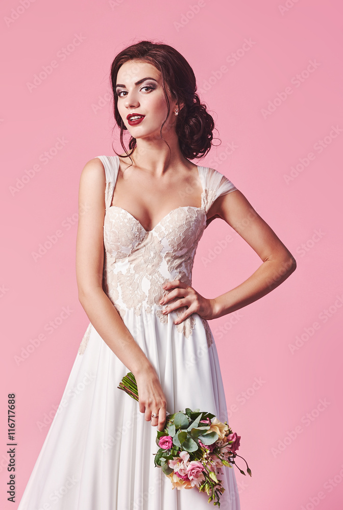 Bride.Young fashion model with perfect skin and make up, beige background, curly hair, flowers in hair Bride.Young fashion model with perfect skin and make up, beige background, curly hair, flowers in hair